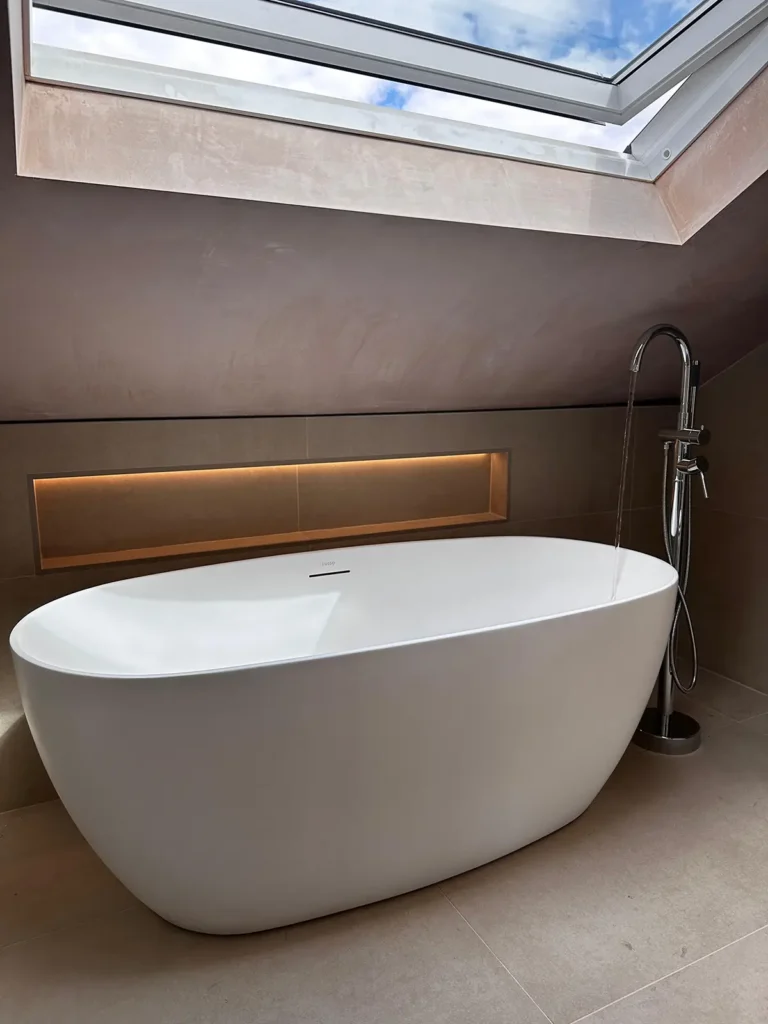 Modern bathroom with freestanding bath, floor-mounted tap and roof window